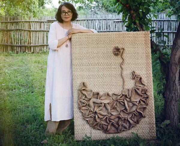 Zhang Jing and her work: a lotus pod growing from a pond of lotus flowers. Photo provided by the interviewee.