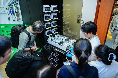 Photo shows guests taking a closer look at the CL1 biological computing system during a live demonstration at the launch event.